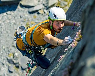 Man climbing rocks wearing Mountain Equipment gear