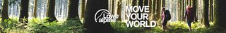 A woman stood at the top of a hill, wearing a Lowe Alpine backpack and holding walking sticks