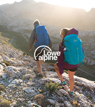 Woman and man hiking carrying Lowe Alpine backpacks.