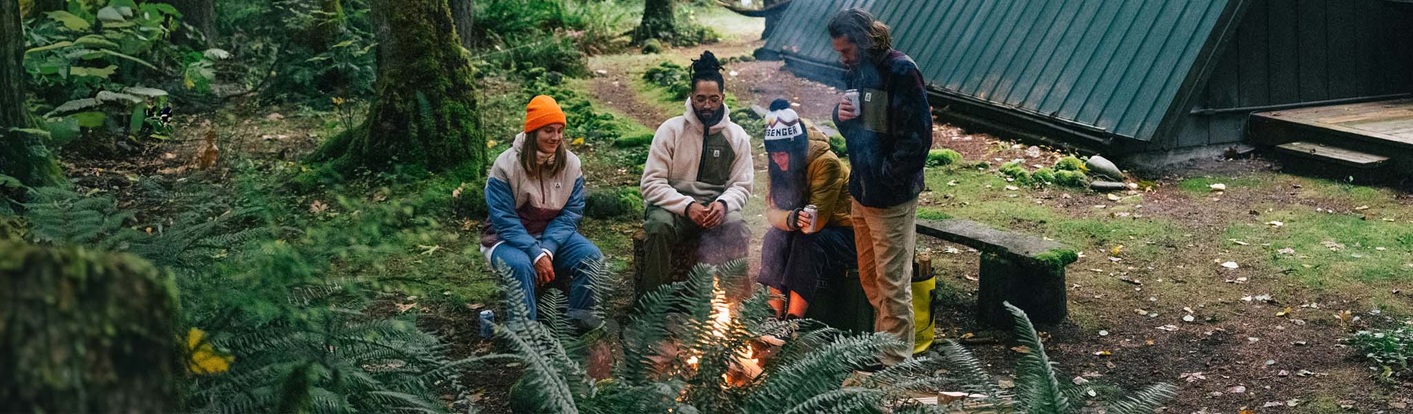People stood around a firepit in Passenger clothing 