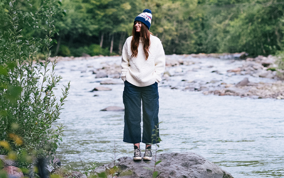 A woman stood by a river in Passenger clothing 