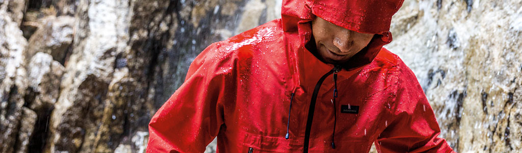 A man walking in the rain wearing a red patagonia jacket