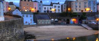 landscape view different coloured houses on a harbour bay at dusk
