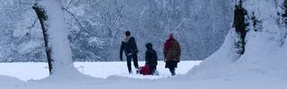 3 People Pulling a Sledge in Snow