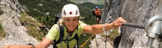 Woman in climbing gear climbing Via Ferratta