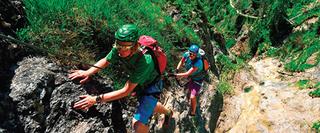 Two people climbing a mountain
