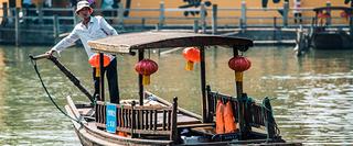 Asian man on a small wooden boat