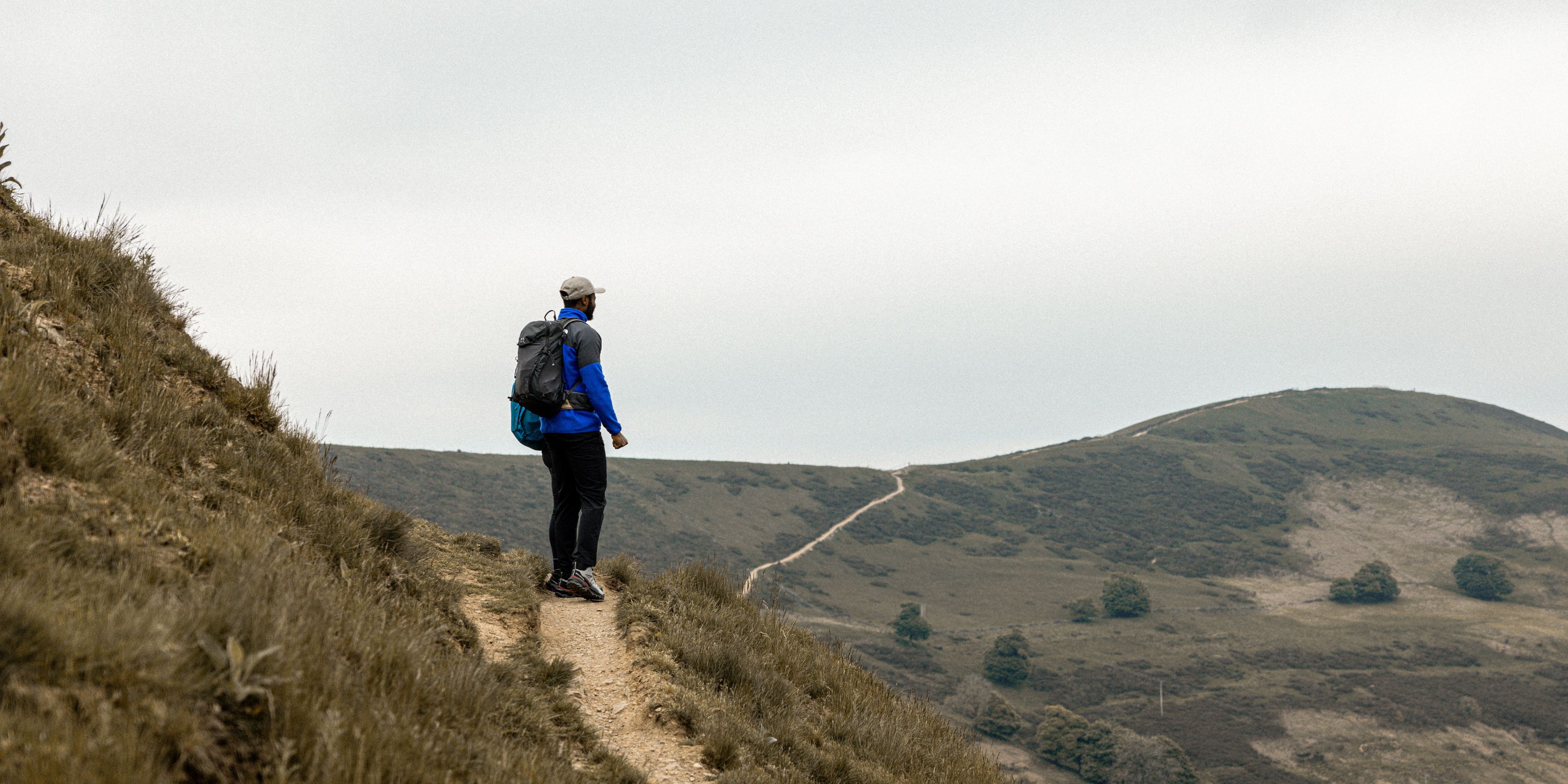 A man looking out into the distance from a hilltop 