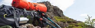 A person is walking on mountains, wearing a rucksack