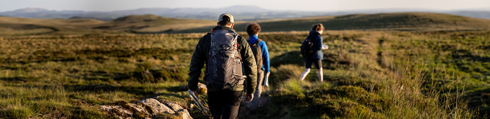 People are hiking outdoors with backpacks