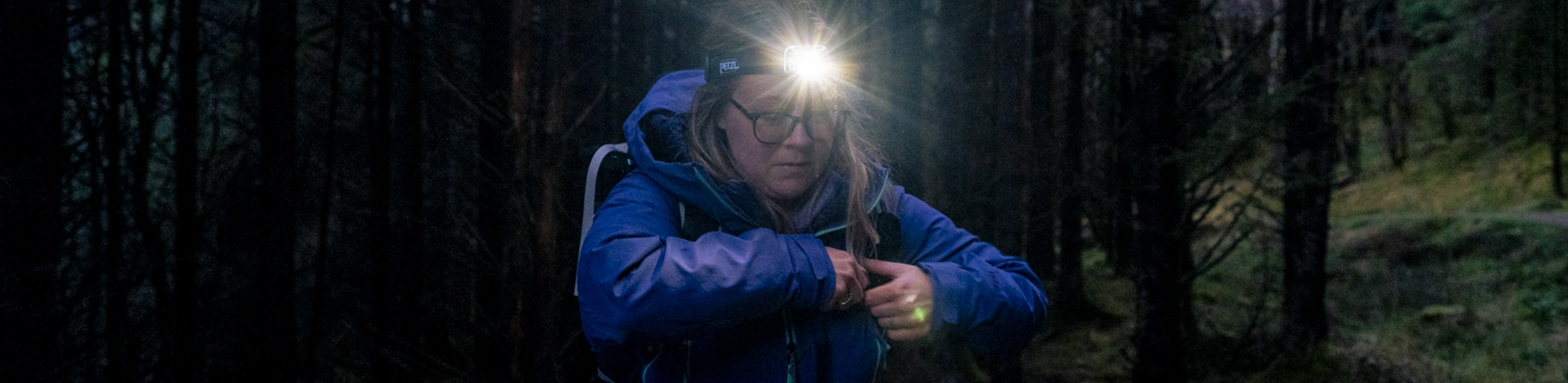 Woman hiking in the night using lighting equipment