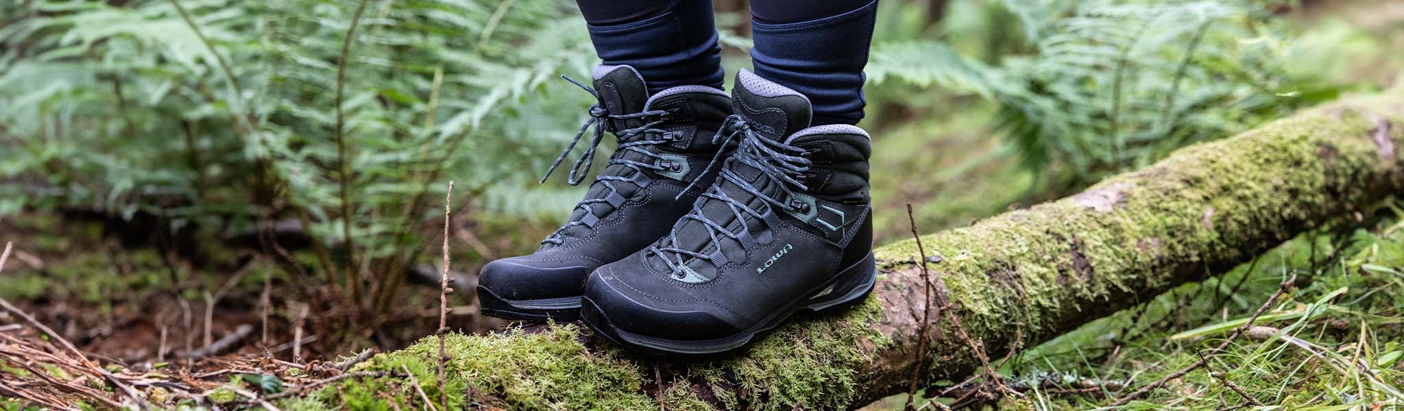 Someone's feet in boots on a fallen tree