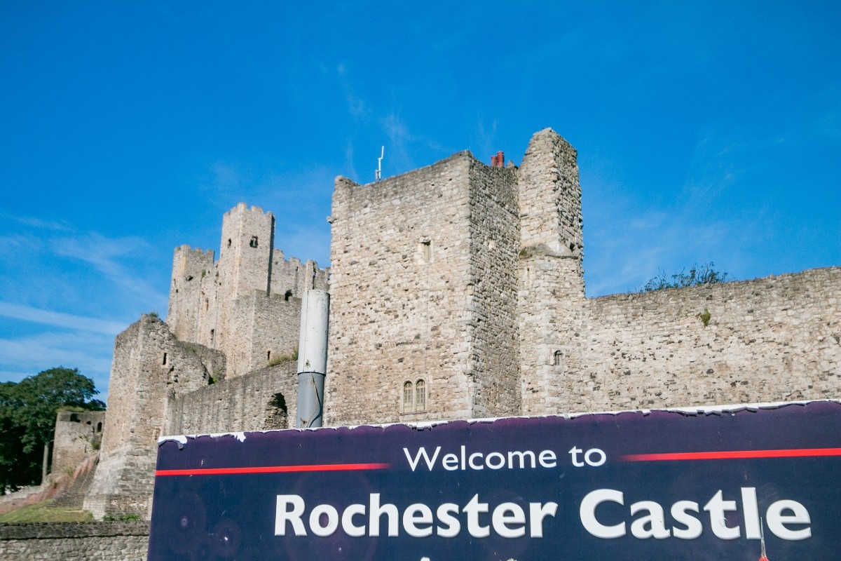 Rochester Castle with a sign reading "Welcome to Rochester Castle" 