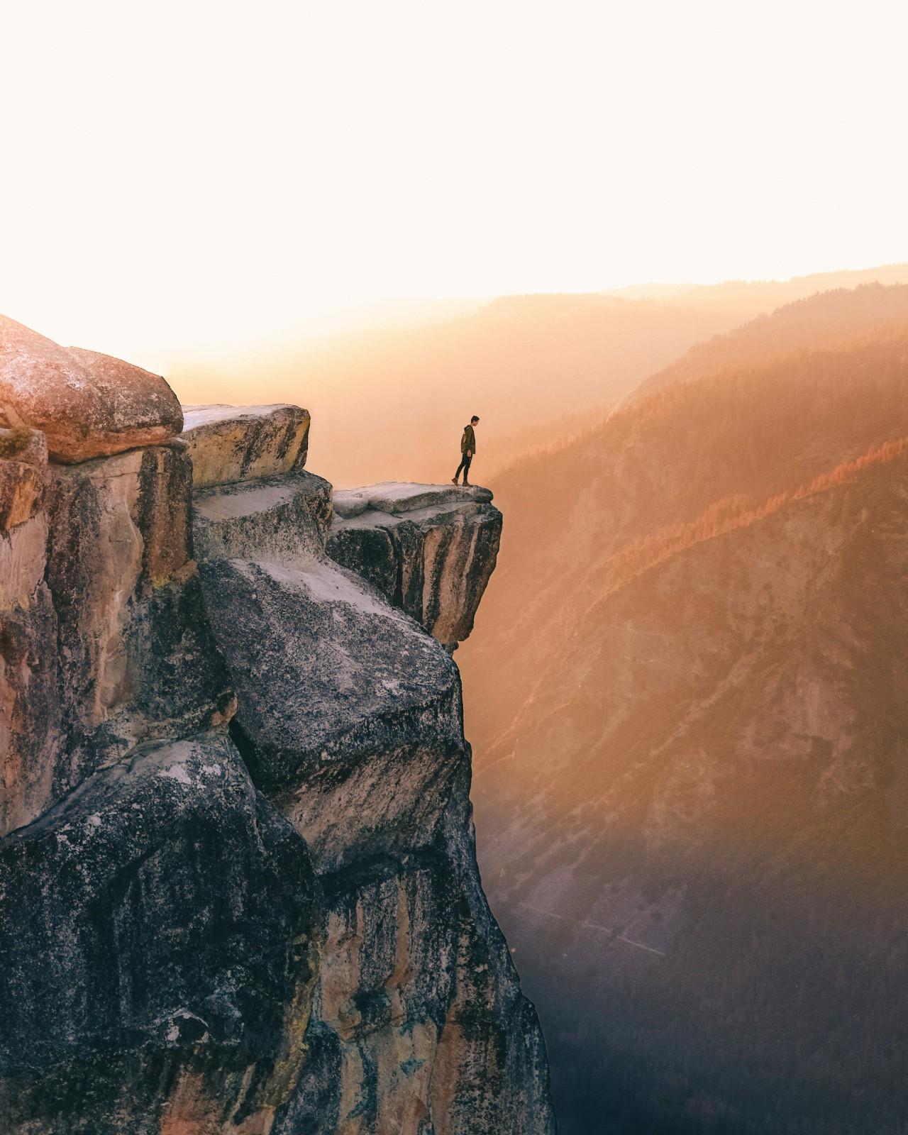 A man standing on a cliff edge in the Yosemite