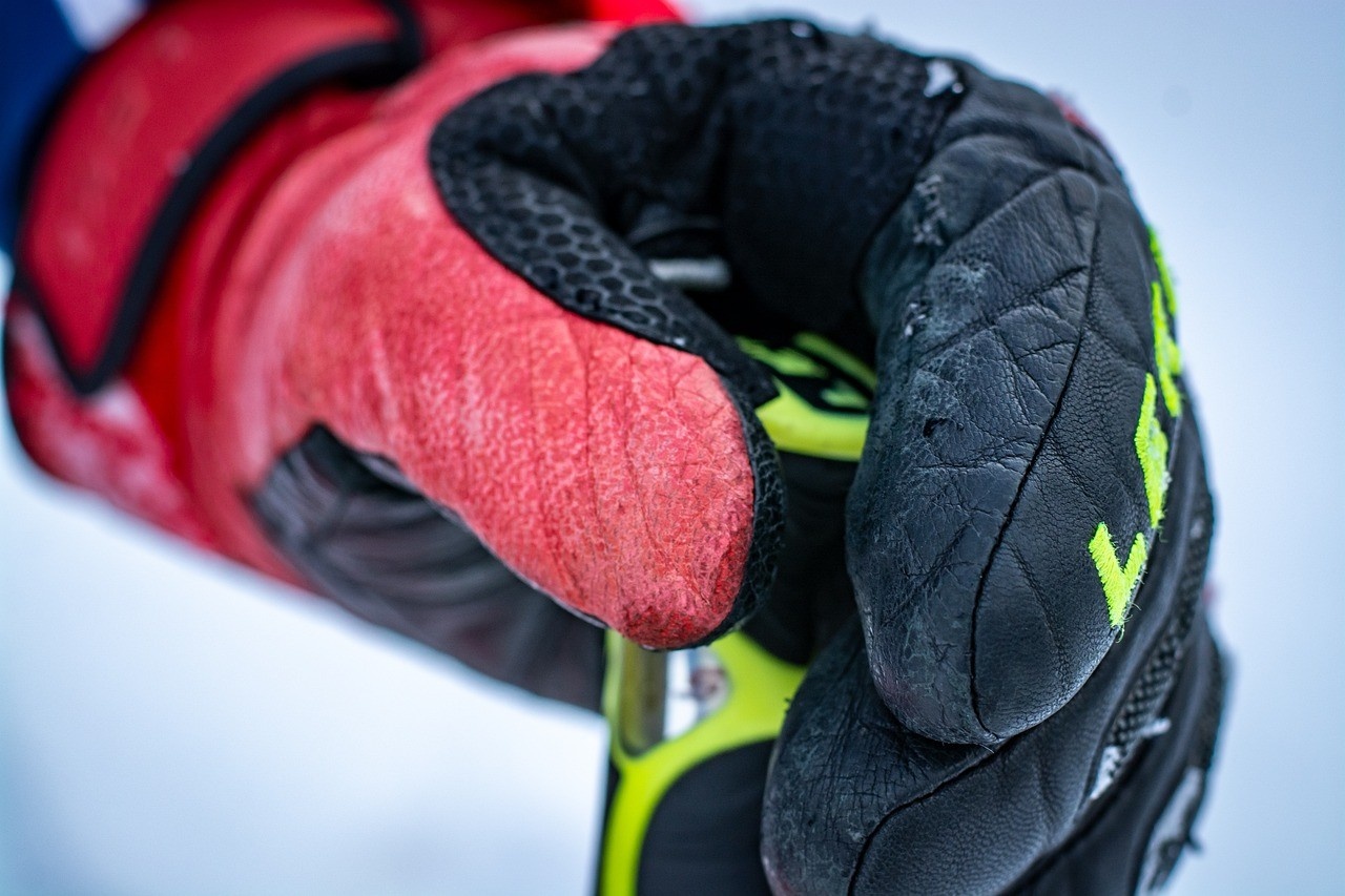 A man holding his ski pole in his winter gloves