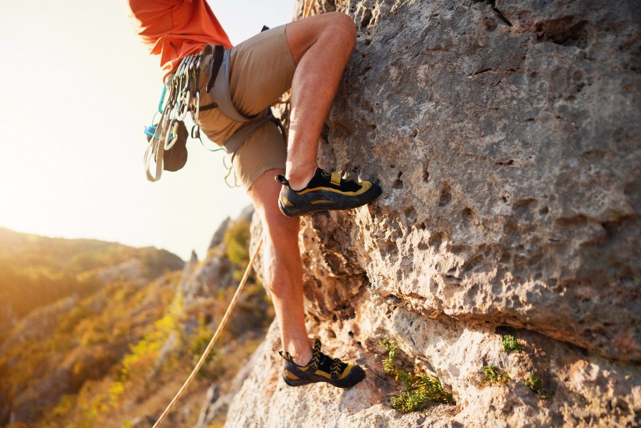 A person climbing up a rock face 