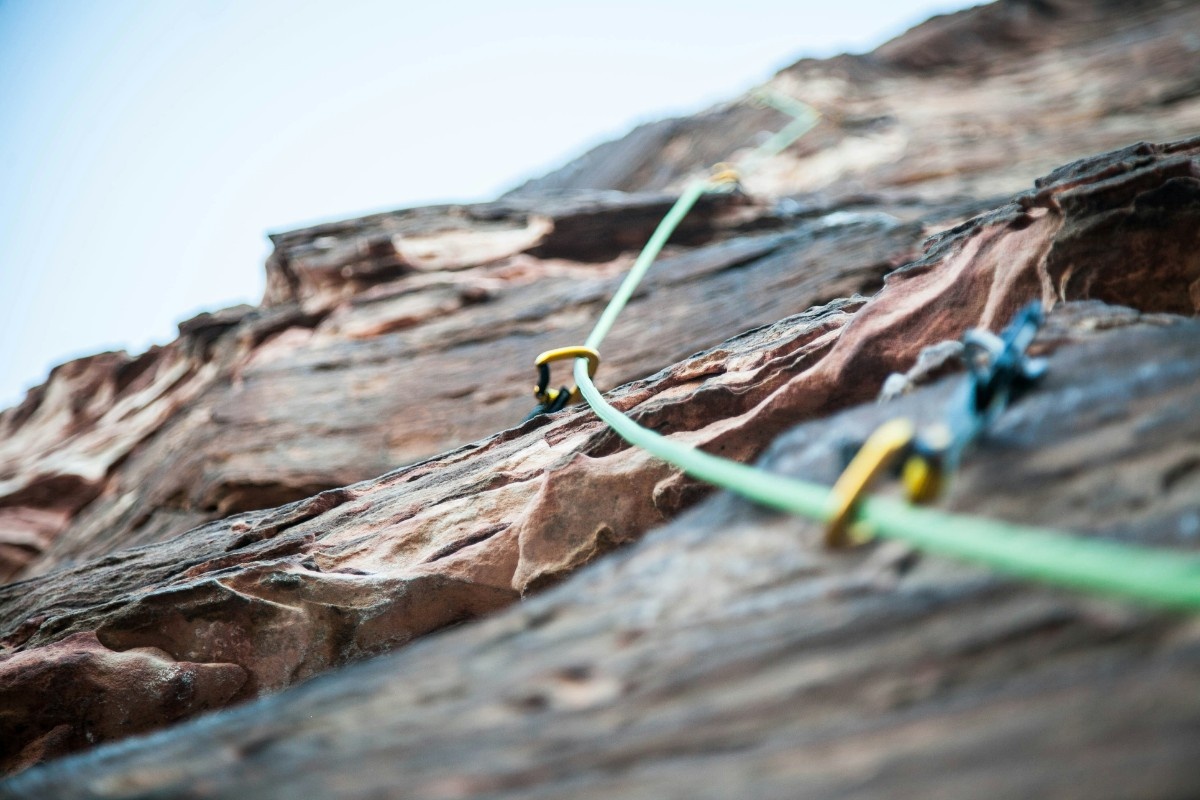 An image of climbing ropes secured to a rock face 